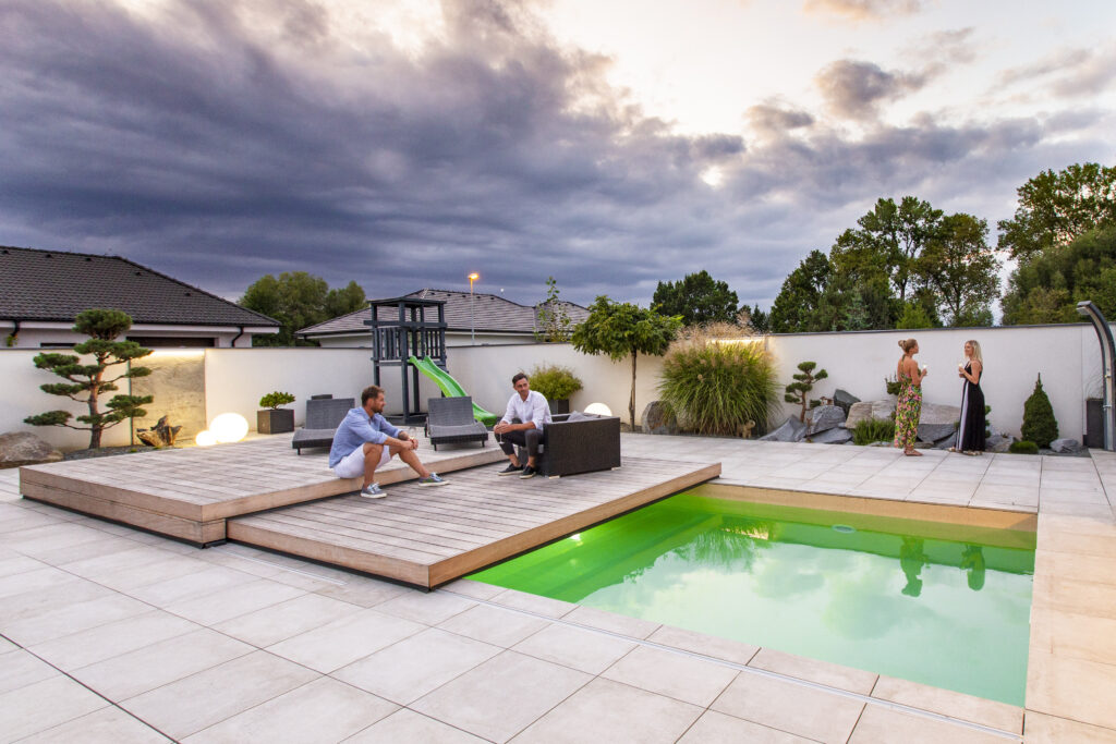 Bazén je vybaven posuvným plochým zastřešením, které dokonale splývá s okolní terasou. Zastřešení chrání bazén před nečistotami a zároveň šetří prostor v zahradě.