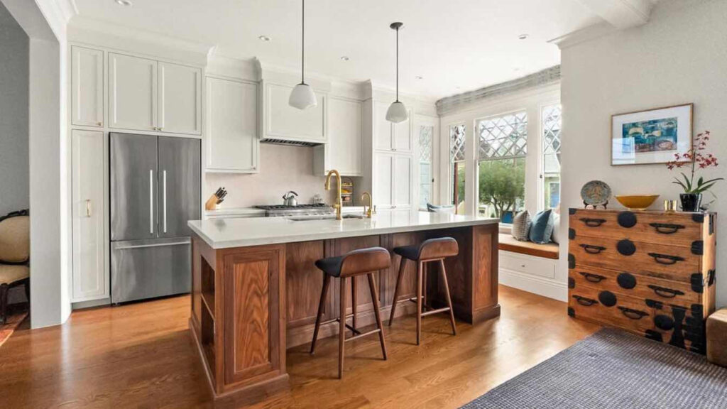 Bílá kuchyň, přírodní dřevo židle a ostrůvek