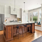 Bílá kuchyň, přírodní dřevo židle a ostrůvek