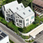 Trojdům postavený z bílého betonu