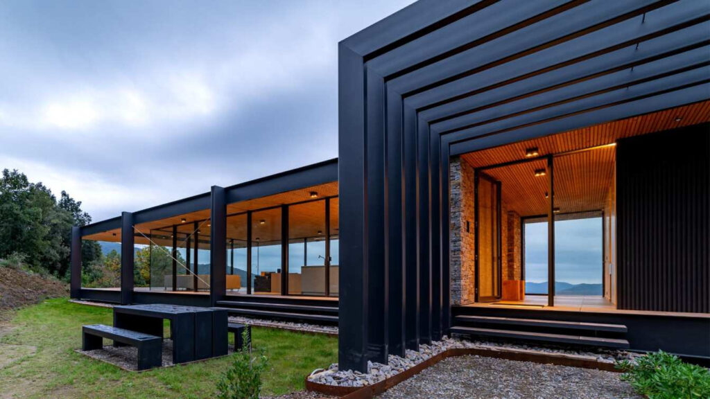 Prosklený rodinný dům na svahu.