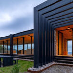 Prosklený rodinný dům na svahu.