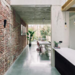 Rekonstrukce řadového domu: elegantní přístavba s ukrytou kuchyní a surové materiály