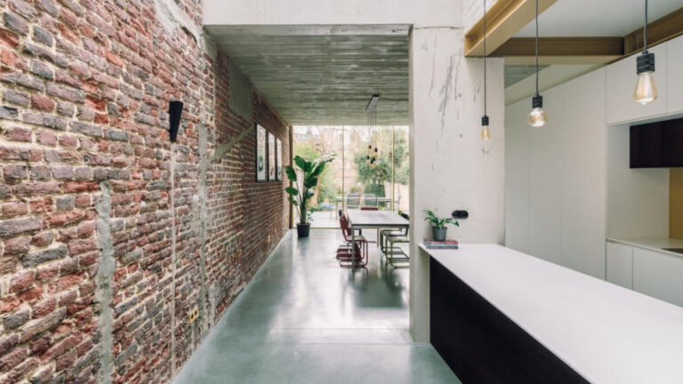 Rekonstrukce řadového domu: elegantní přístavba s ukrytou kuchyní a surové materiály