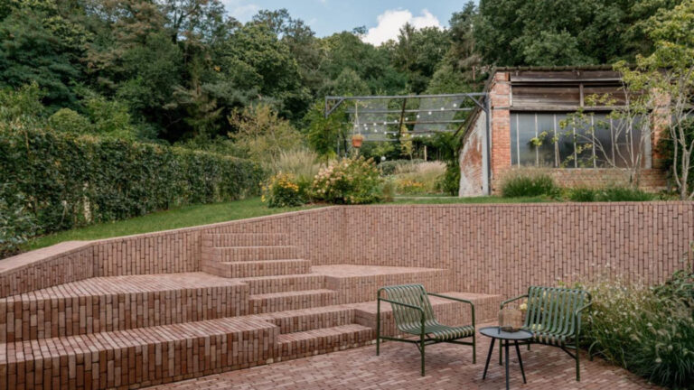 Cihlové schody a opěrné zdi na terase obložené vertikálně kladenými světle červenými cihlami – teplá textura navozuje hravý a útulný vzhled.